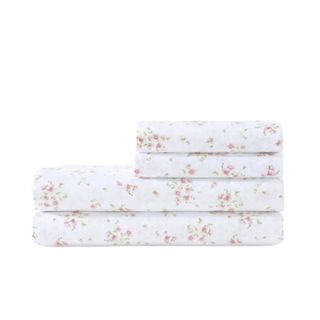 A set of pink floral bed sheets, with two folded sheets on the bottom and two pillowcases folded on top