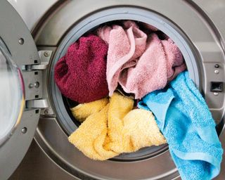 Multicolored towels spilling out of a washing machine